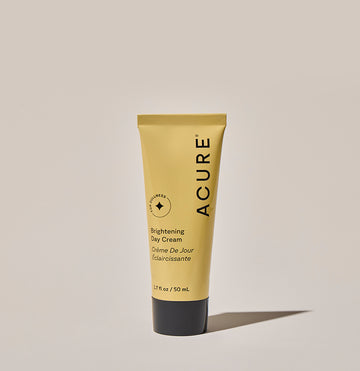 A tube of ACURE Brightening Day Cream against a neutral background.
